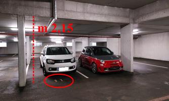 A parking garage with two vehicles, a white car on the left and a red car on the right. The ceiling height is 2.15 meters.