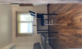 A small, bright room with a table and two chairs.  
On the wall, there is a bench and a window with a view of nature.