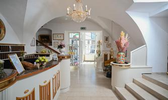 An elegant reception area with a warm atmosphere. The room is well-lit and adorned with plants and decorative elements.