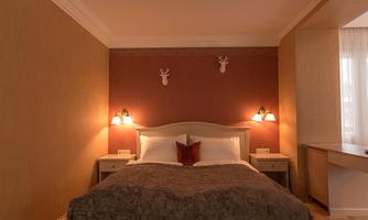 A cozy bedroom with a large bed and a soft bedspread.  
The walls are painted in warm tones, and gentle lamps provide pleasant lighting.