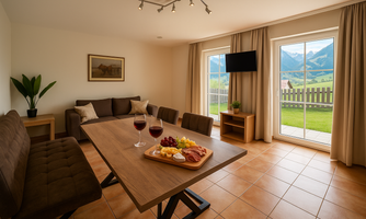 A bright living room with a large table where wine and snacks are served. Through the windows, you can see the mountains and a green landscape.
