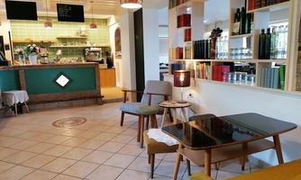 A cozy café with a modern interior. There is a small bar area and comfortable seating.