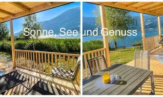 A cozy balcony overlooking a lake and the surrounding nature. The sun is shining and creating a pleasant atmosphere for relaxation.