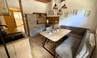 A modern kitchen with a dining area. The room features warm wood tones and a cozy atmosphere.