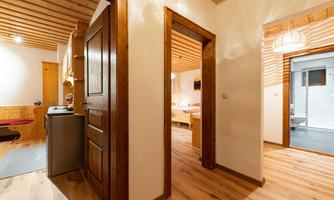 A cozy apartment with wooden paneling and an inviting hallway. The rooms are bright and well-designed.