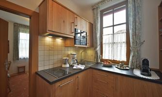 A modern kitchen with wooden cabinets and a kitchen unit. The window lets in plenty of light and creates a cozy atmosphere.