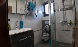 A modern bathroom with a shower, a sink, and a toilet. Towels included.