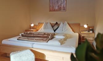 A cozy bedroom with a large bed and decorative pillows. Soft light from bedside lamps creates a relaxed atmosphere.