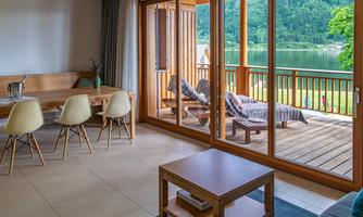 A bright and modern apartment with a view of a lake. The living area has large windows that let in plenty of daylight.