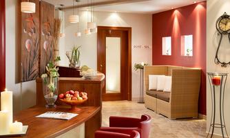 An elegant reception area with warm colors and stylish furniture.  
Fresh plants and pleasant lighting create an inviting atmosphere.