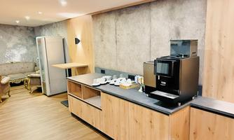 Our newly designed break room provides seminar participants with a relaxing atmosphere for rest and informal networking. The combination of modern wooden elements and elegant upholstered furniture creates a comfortable ambiance. A high-quality coffee machine ensures fresh coffee and hot beverages, while the spacious room offers plenty of space for a pleasant break. Perfect for recharging and unwinding in a calm setting.