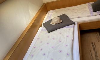 A cozy room with two single beds and light-colored walls. The beds are equipped with white bedding and pillows.