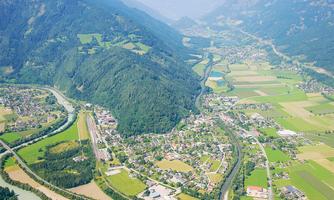 A picturesque landscape with hills, forests, and gentle fields. A small river winds through the valley, connecting the villages.