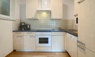 A modern kitchen with bright furniture and a stove. The fittings include a sink and kitchen appliances in a functional design.