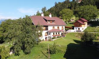 A cozy country house in the midst of a green meadow landscape. Surrounded by trees and hills, it radiates rural charm.