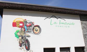 The image shows a colorful mural with motorcycles and figures. Above it is the inscription "La Imania Pension."