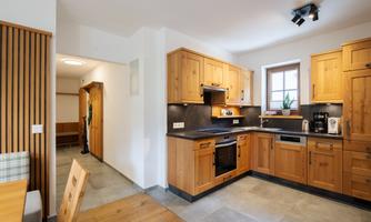 A modern kitchen with wooden cabinets and elegant appliances. The room is bright and inviting, perfect for cooking.