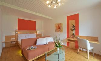 A modern bedroom with a comfortable bed and a beautiful, bright design. The room has a cozy seating area and a stylish decor.