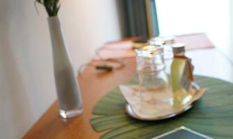 A beautiful table with a welcoming brochure, a glass of water, and a stylish lamp. A vase with fresh flowers complements the cozy atmosphere.