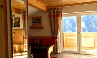 A cozy room with wood decor and a large mirror.  
Large windows offer a view of the mountains and let in plenty of light.