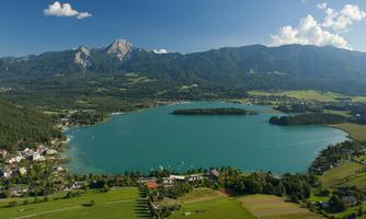 A beautiful, clear lake surrounded by mountains and green meadows. The landscape is picturesque and invites relaxation.