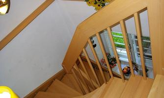 A wooden staircase leads downwards. There are decorations like sunflowers and fruit near the windows.