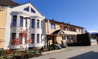 A bright building with modern and traditional elements. The sky is clear and blue, and the surroundings are well-maintained.