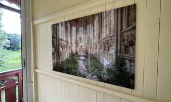 An impressive mural depicts an abandoned cathedral overgrown with plants. The image conveys a calm and mystical atmosphere.