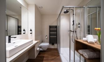 A modern bathroom with shower and sink. The wooden details give the space an inviting atmosphere.
