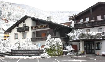 A chalet-style building with the inscription "Kaiserburg". The surroundings are covered in snow and the mountains are visible in the background.