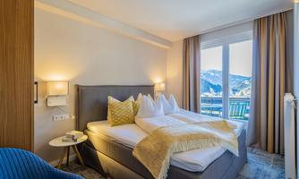 A cozy bedroom with a double bed and a beautiful view of the mountains. The modern windows let in plenty of light and create an inviting atmosphere.