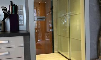 A modern interior with an open door and glass walls. The area is designed to be bright and welcoming.