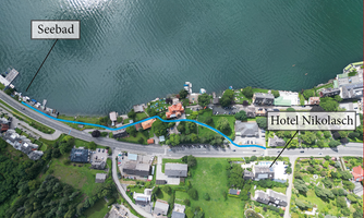 Aerial view of a picturesque coastal area with clear waters. Markings indicate the seaside resort and the Nikolaasch Hotel.