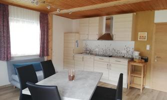 A modern kitchen with a dining area. The room is brightly and cheerfully designed.