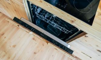 A modern kitchen with an open dishwasher. The dishwasher is elegantly finished in wood and shows dishes inside.