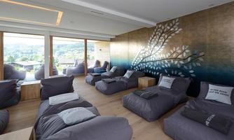 A modern relaxation room with cozy bean bags and large windows. The wall is decorated with a beautiful, artistic motif.