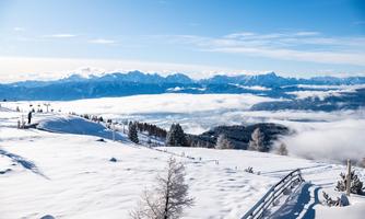 A beautiful snow-covered mountain with a clear view of the surrounding peaks. The landscape is calm and harmonious, surrounded by clouds.