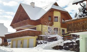 A beautiful house in winter with lots of snow. The architecture is traditional with a snow-covered roof and balconies.