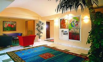 An elegant room with a colorful carpet, modern furniture, and large plants. A creative painting hangs on the wall.