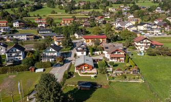 A picturesque landscape with several houses and plenty of green. The surroundings feature gentle hills and a tranquil atmosphere.