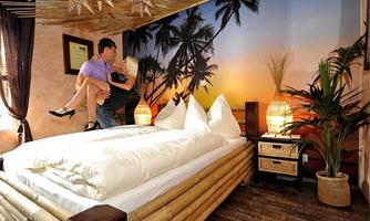 A romantic room with a bamboo bed and a tropical mural in the background. The ambiance is warm and inviting, perfect for couples.