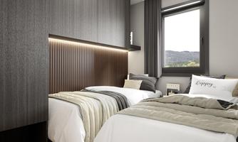 A modern bedroom with two twin beds and elegant wooden decor. The room has a large window that lets in daylight.
