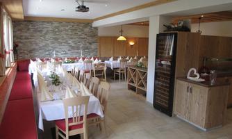 An inviting dining room with tables set for guests. The walls are designed in warm colors, and there is a cozy atmosphere.