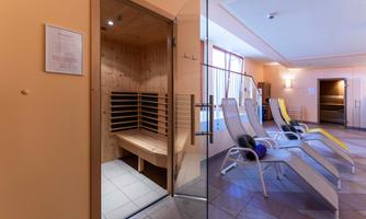 A quiet wellness area with a modern sauna and loungers. The atmosphere is relaxed and inviting.