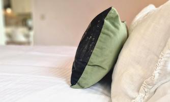A cozy bed with decorative pillows. The pillows in soft colors give the room a relaxed atmosphere.