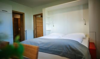 A cozy bedroom with a double bed and modern furniture. The walls are light, and there is a pleasant atmosphere.