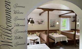 An inviting restaurant with cozy seating and a friendly atmosphere. The wall reads "Welcome" in different languages.