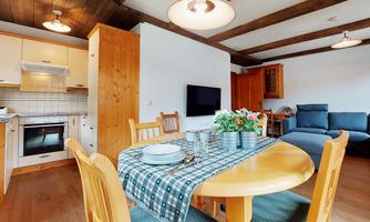 A cozy eat-in kitchen with a dining table and a kitchen. The rooms are bright and friendly furnished.