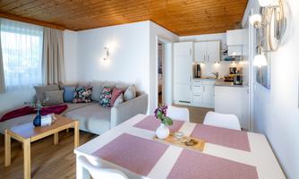 A cozy apartment with a seating area and a modern kitchen. The space is bright and inviting, perfect for relaxing hours.