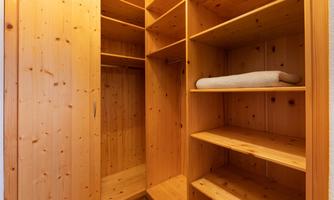A bright wood cupboard with open shelves and a towel. The interiors are well-organized and inviting.
